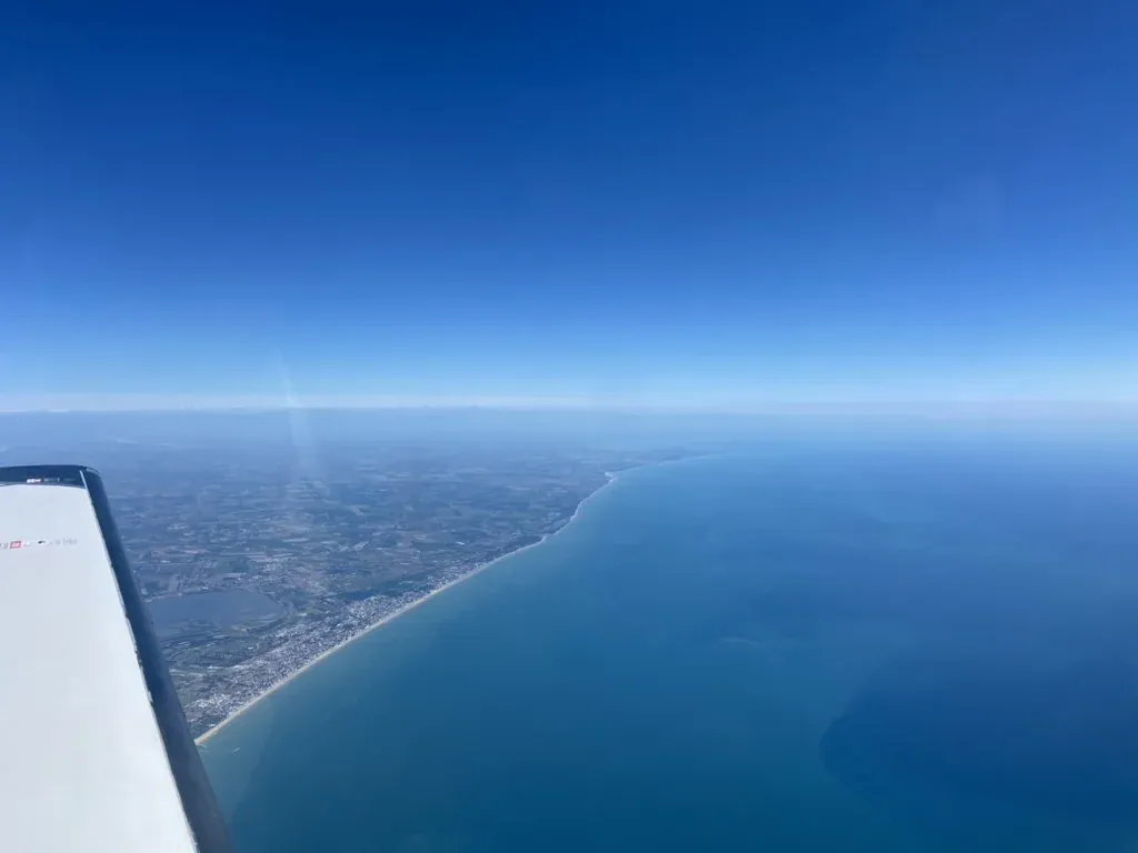 Blick aus einem APEA-Flugzeug auf eine Küstenlinie während eines Navigationsflugs