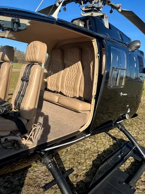 Geöffneter Passagierraum einer MBB BO105 mit beigefarbenen Sitzen