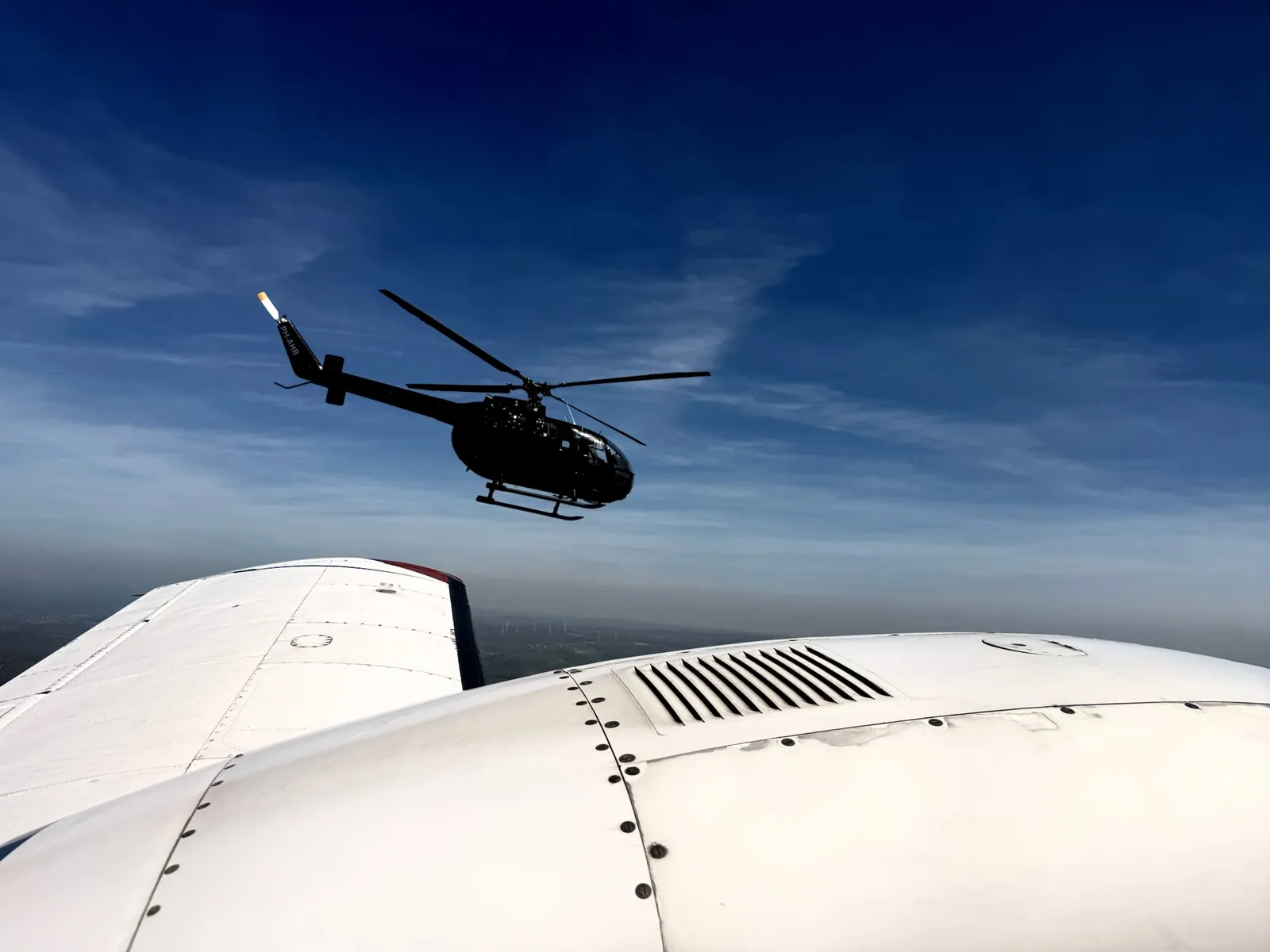 MBB BO105 PH-AHB im Flug, fotografiert aus einem begleitenden Flugzeug